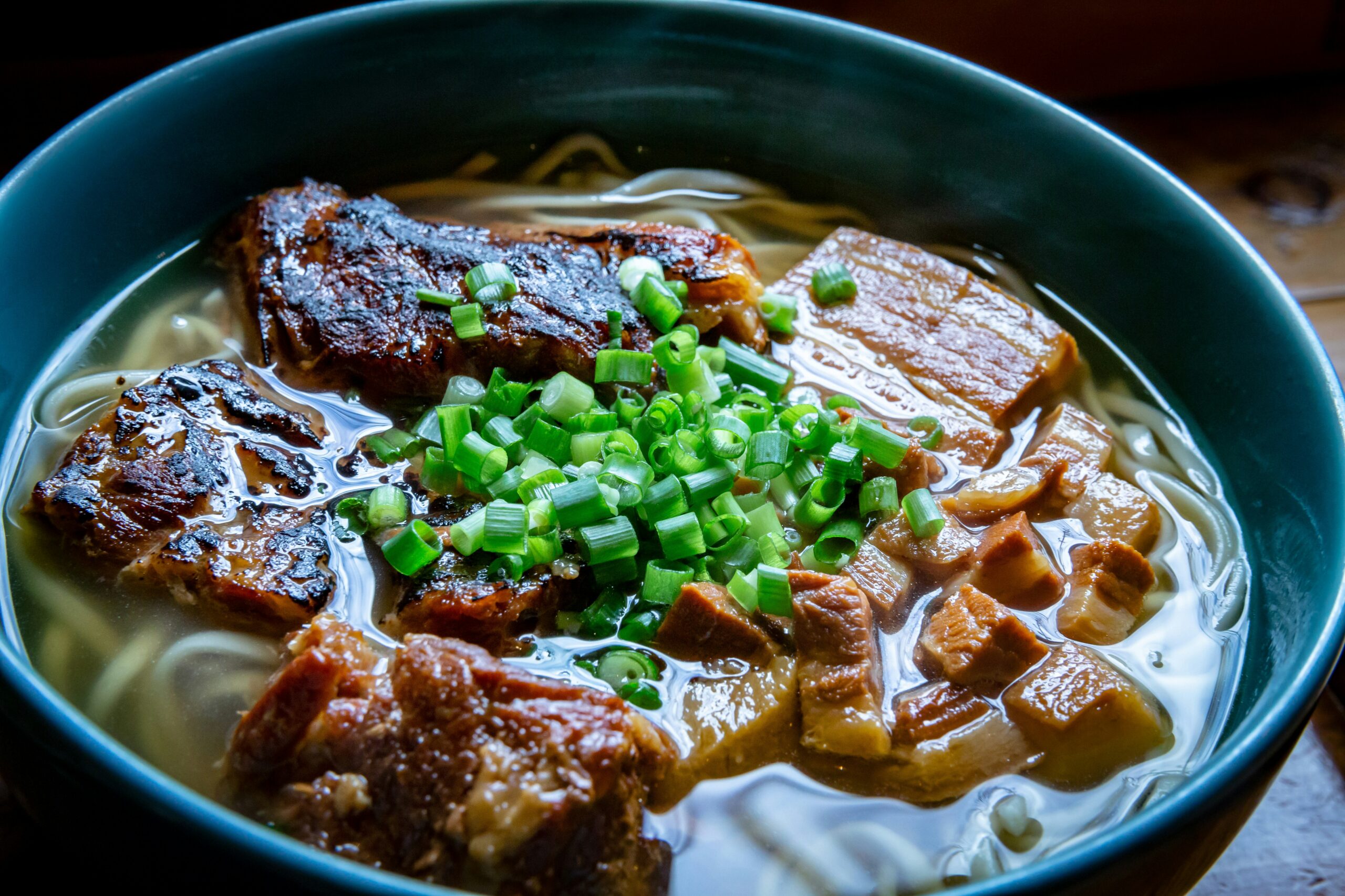 沖縄そばとは、そば粉を一切使わず小麦粉100%で作られる太い麺に、豚骨やカツオ節ベースの出汁を合わせた沖縄県の郷土料理です。