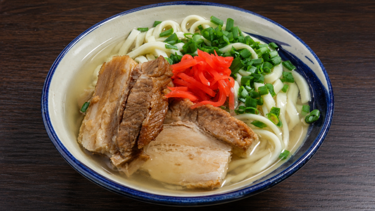 沖縄そばに豚肉、青ねぎ、紅しょうがをのせた料理。